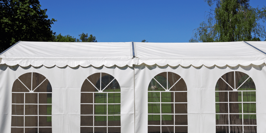 White tent with windows in yard